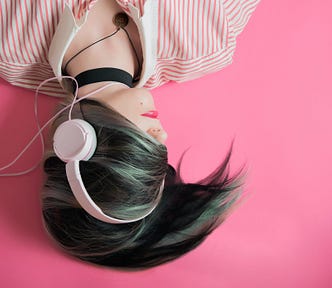 girl listening to music on pink headphones