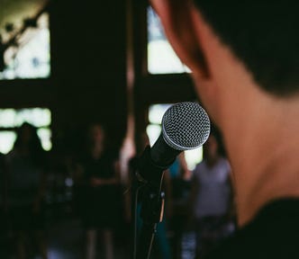 A man is talking on stage to an audience.