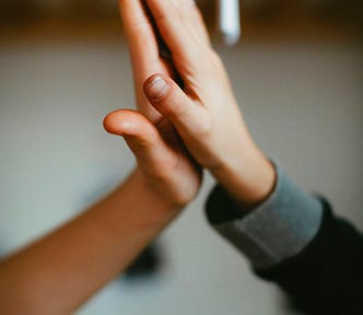 Two young boys make a friendship hand clap