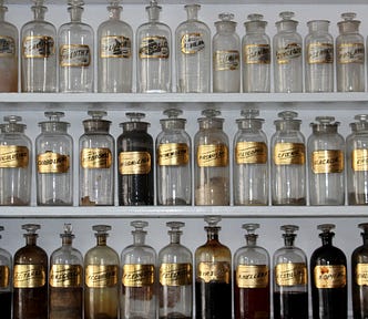 Apothecary style glass bottles and jars lined up on a shelf