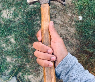 Photo of a hand holding a hammer.