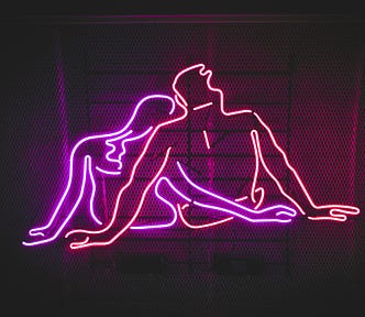 Neon sign depicting two abstract human figures in intimate embrace, created with pink and red glowing tubes against a dark mesh background.