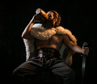 seated man guzzling ale and holding a sword