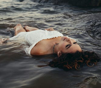 A woman lying on her back in churning waters