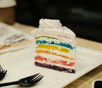 Nommy looking piece of rainbow cake