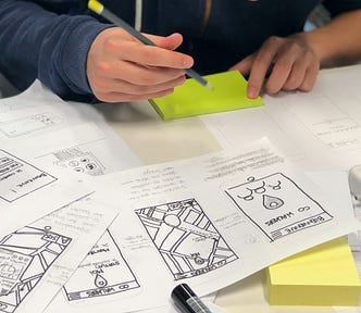 a person sitting down to draw out prototypes