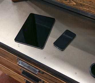 An iPad and an iPhone on a counter.