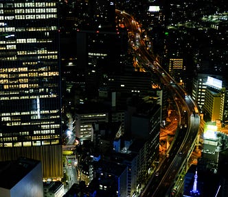 A panoramic view of a large city from a high vantage point during the night.