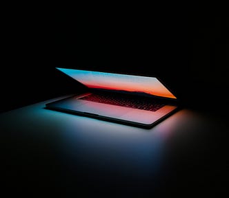 Dark room with a half-open macbook pro