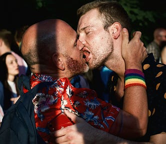 Two men kissing passionately.