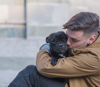 A man kisses his belovved pet dog