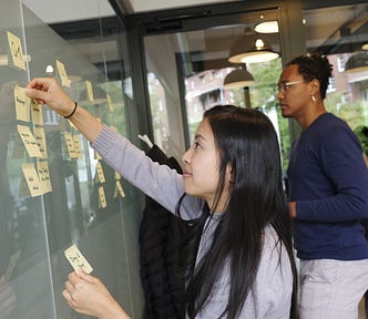 Two people brainstorming on a whiteboard