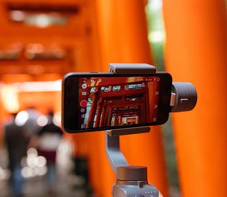 An image of a phone filming the Fushimi Inari gates in Kyoto