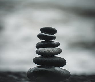 A stack of smooth stones sits against a backdrop of the ocean.