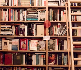 A very large shelf of messily arranged books