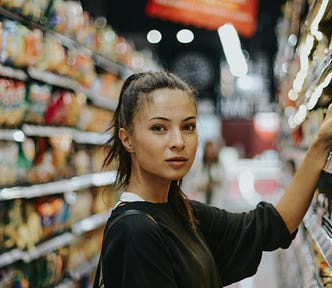 A girl in a long supermarket aisle