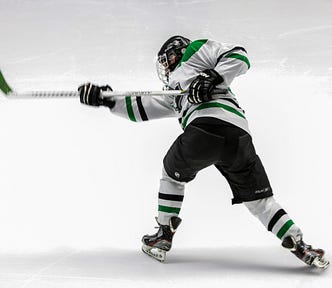 A hockey player making a slap shot