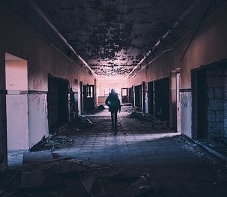 Person walking down a corridor in a run-down building