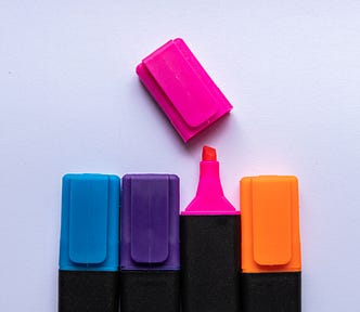 Four highlighters with one cap removed