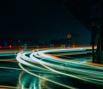 Photo of a roundabout at night with traffic, symbolizing requests for our services.