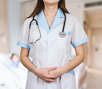 An image of a person with long hair, wearing a nurse’s uniform and a stethoscope hanging around her neck.