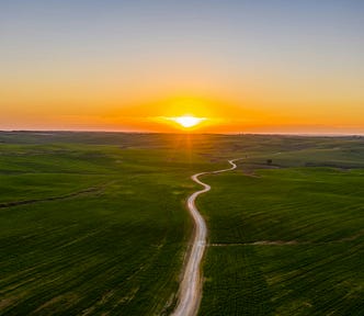 Sunrise over a lonely road in farm country.