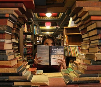 photo of a young woman framed by a circle of library books