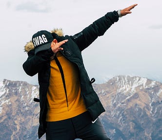 A man dabbing wearing a SWAG hat.