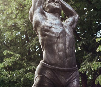 Iron statue of a muscular man.