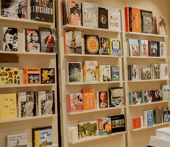 Bookshelves in a bookstore showing different genres of books for sale.