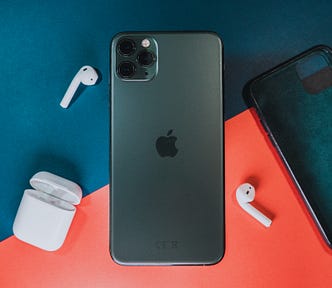 iPhone 11 Pro Max, its case, and AirPods on a table