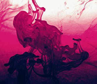 A dancing woman appears to emerge from a pool of dark pink liquid