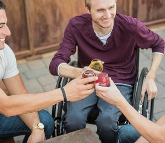 Three men holding drinks smile and toast