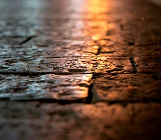 A macro photograph of a cobblestone street in the night light.