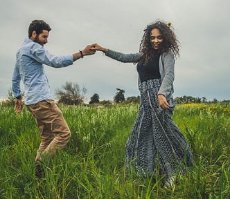 A couple dances in a summer meadow, representing the summer of love.