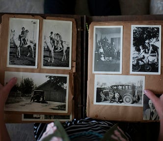 A person holding a photo album with grayscale photographs.