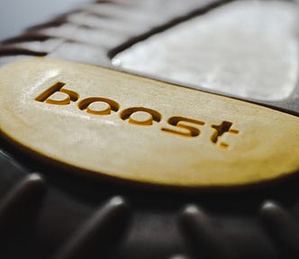 The letters boost on a beige disc. It actually might be a brand name on the bottom of a shoe.