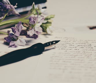 A flower and a pen on a notebook.