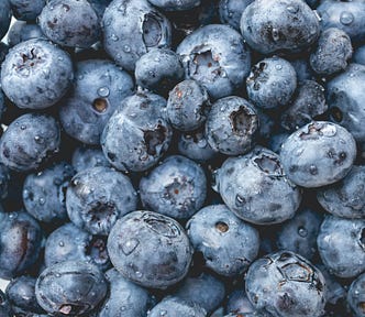 Photo: Up close picture of a bunch of fresh picked blueberries.