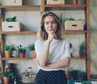 Portrait of upset young woman expressing negative emotions standing inside modern loft style apartment. Emotional reaction, disappointment and people concept.