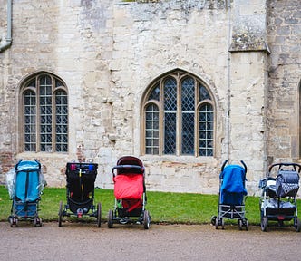 Seven push-chairs parked outside a building