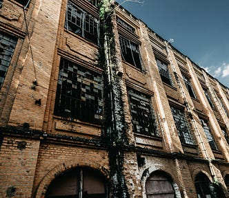 A large old, seemingly deserted factory building.