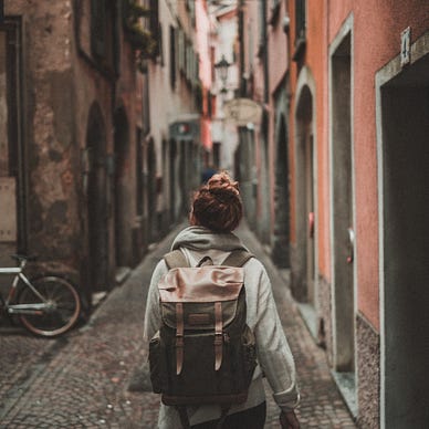 Person wearing a backpack walking in an alley