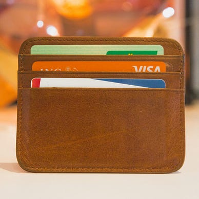 A brown card holder with 3 credit cards