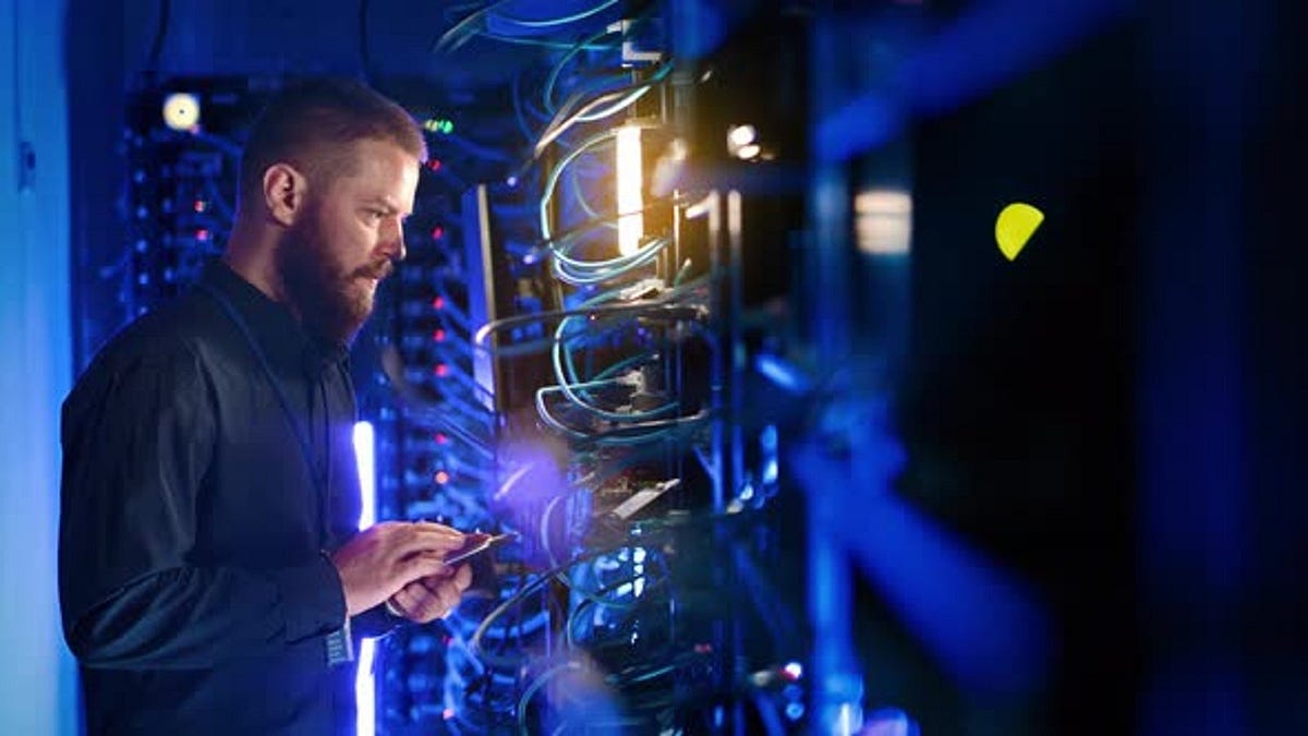 Man managing data in a server room - Spectralsilhouette - Medium