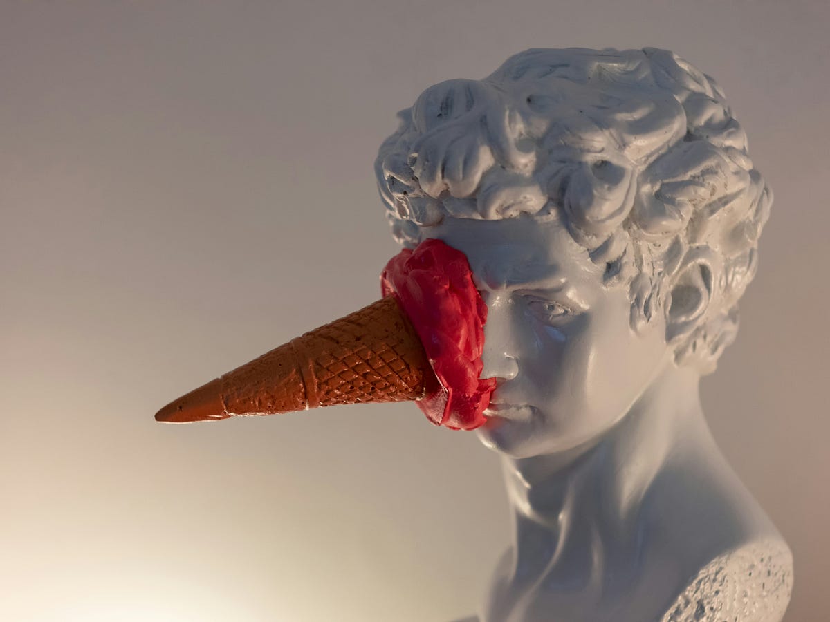 'a statue of a man with an ice cream cone on his face'