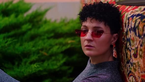  Stylish model with short hair and glasses, posing by a retro car ...