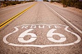 A long straight empty road with Route 66 written on it