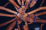 A group people leaning in to create a hand stack.