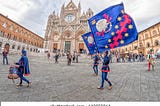 Siena square with people in medieval costume holding flags and drums